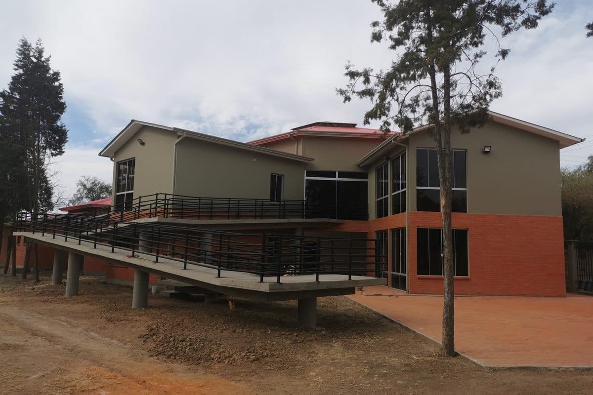 Colegio Andalucía terminado: bloque de aulas de dos plantas con rampa accesible de hormigón