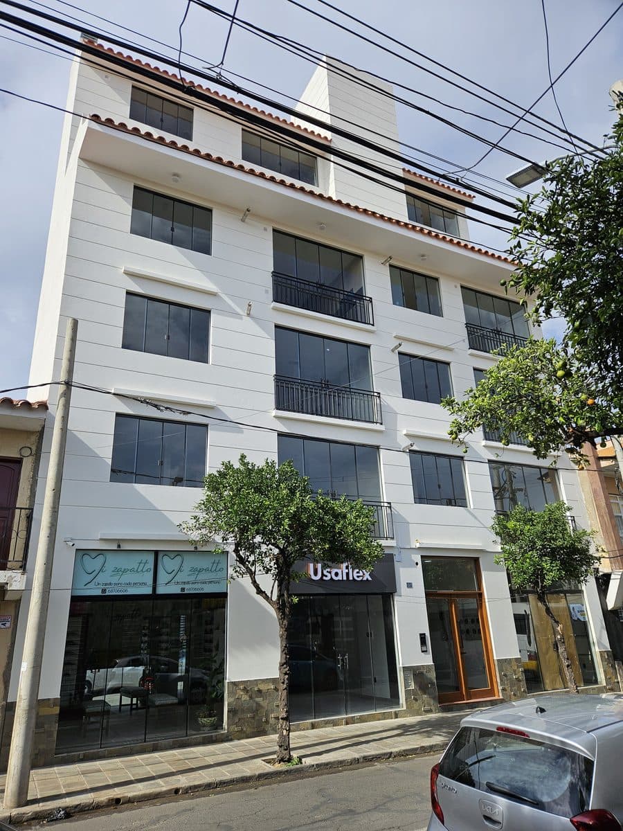 Fachada terminada del edificio Verona: cinco niveles, locales comerciales en planta baja y balcones metálicos