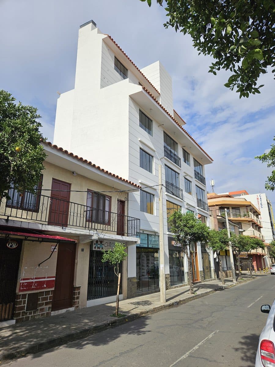 Edificio Verona visto desde la calle, con la fachada blanca y la cubierta de teja terminadas